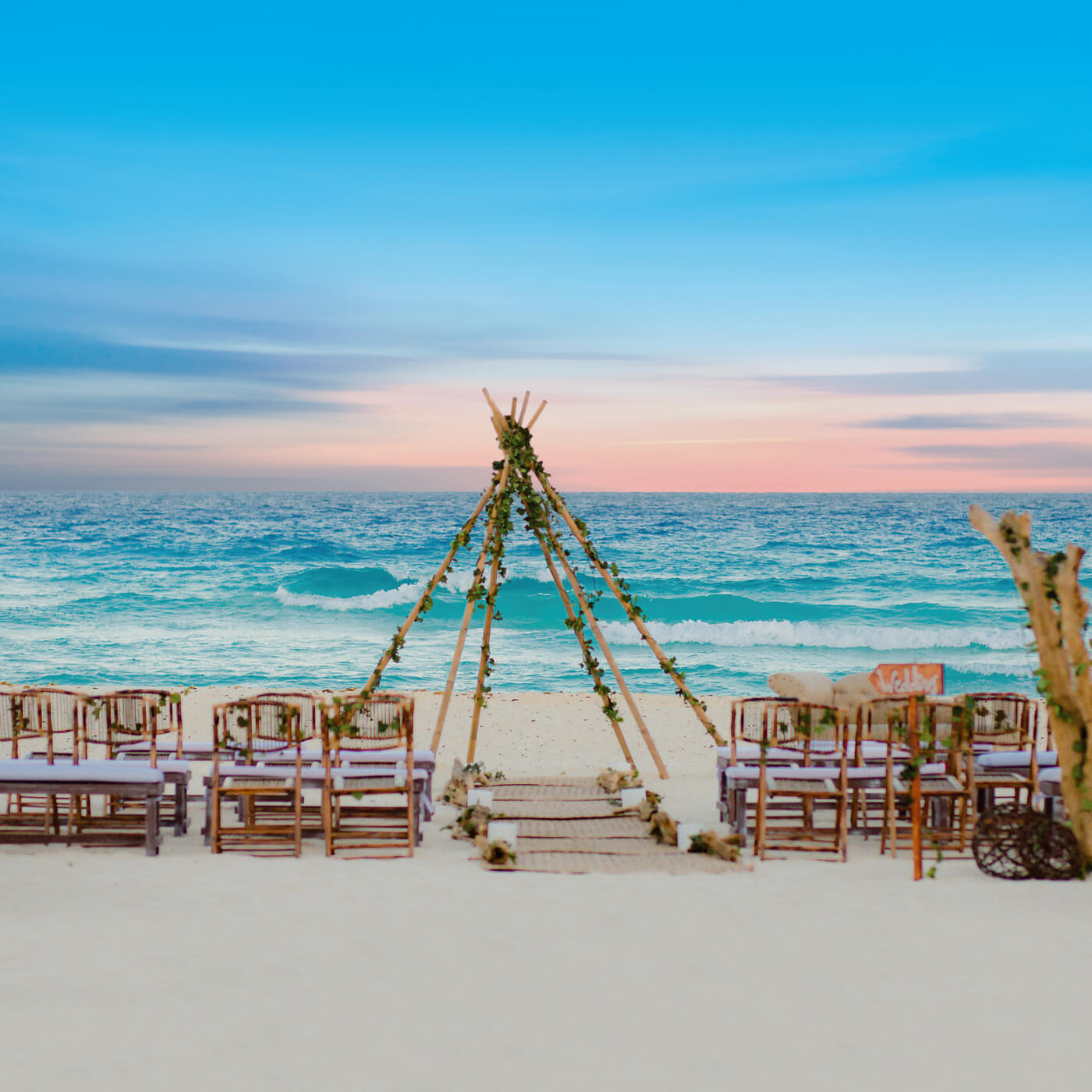 Asientos para novios en altar con techo para sombra junto a la playa en el Hotel Grand Oasis Cancun