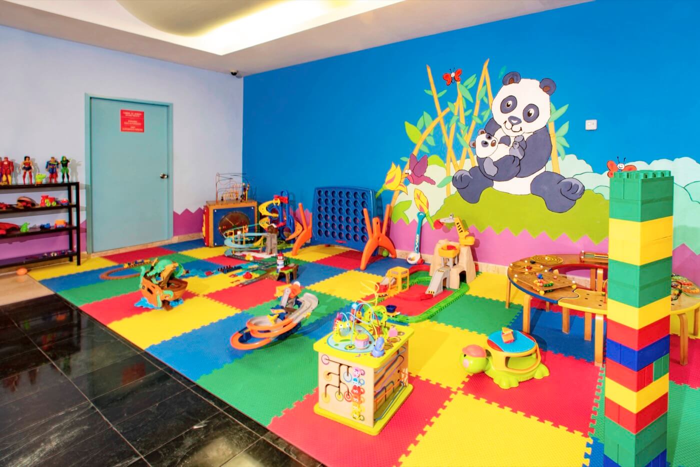 Playground at KiddoZone with consoles and puff armchairs at Hotel Grand Oasis Palm