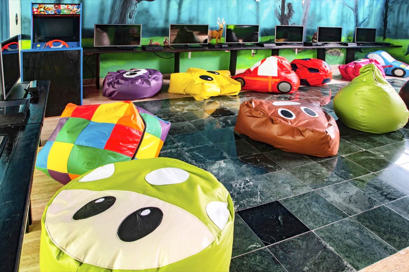 Playground at KiddoZone with consoles and puff armchairs at Hotel Grand Oasis Palm