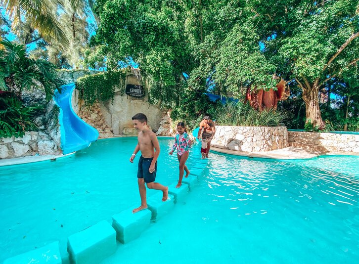 Three Mariachis with stringed instruments in the pool area to entertain the guest