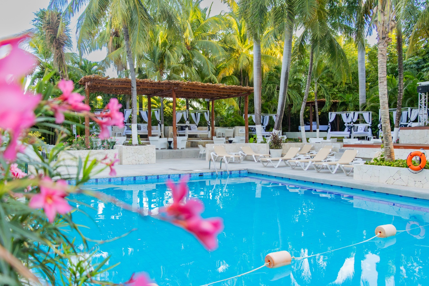 View to the beach with beds and palapas in Oasis hotels